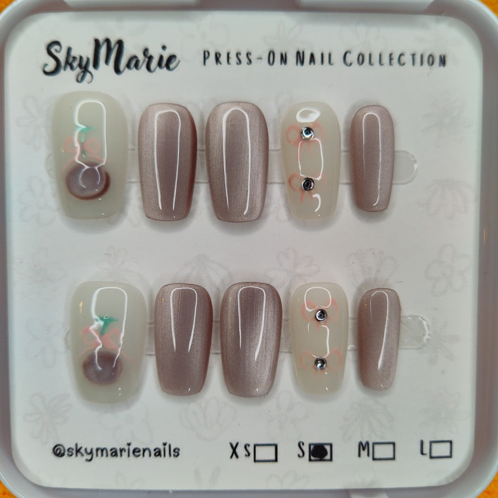 SkyMarie small press-on nails: shimmering mauve cat eye and milky-white with pink floral designs & rhinestones.