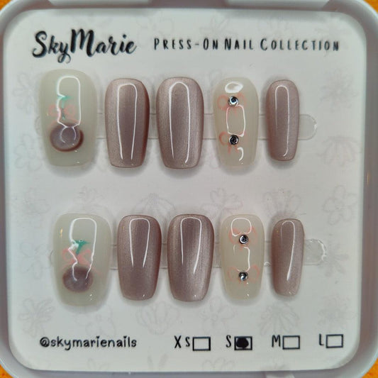SkyMarie small press-on nails: shimmering mauve cat eye and milky-white with pink floral designs & rhinestones.