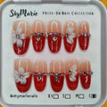 Large SkyMarie red & nude ombre press-on nails with 3D white flowers, rhinestones, and pearls.