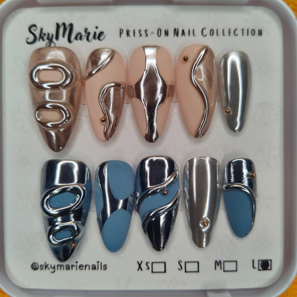 SkyMarie Large abstract chrome metallic press-on nails in nude, rose gold, blue, and silver.